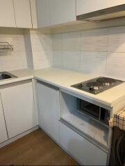 Modern compact kitchen with white cabinetry and appliances