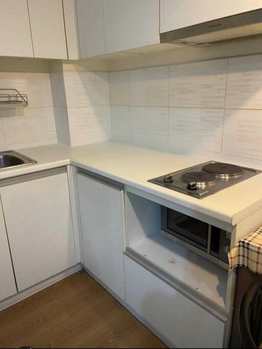 Modern compact kitchen with white cabinetry and appliances