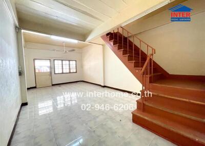 Spacious living room with tiled floor and staircase