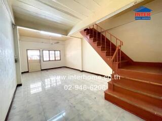 Spacious living room with tiled floor and staircase