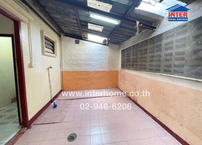 Covered utility area with pink tile flooring and partially open roof