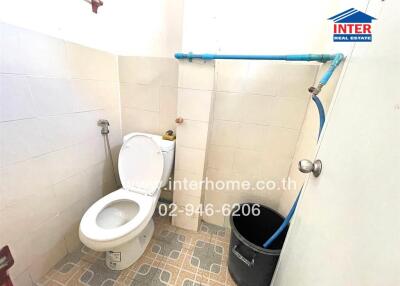 Small bathroom featuring a toilet and utility bucket