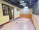 Utility room with tiled floor, wall vent, and security bars on window