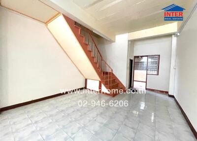 Spacious and bright living area with tiled floors and staircase