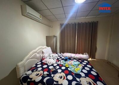 Bedroom with bed, air conditioner, curtains, and Mickey Mouse bedspread