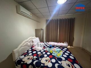 Bedroom with bed, air conditioner, curtains, and Mickey Mouse bedspread