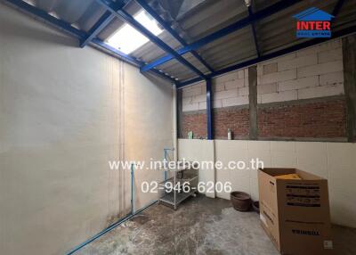 Enclosed utility room with a metal roof, masonry walls, and cardboard boxes.