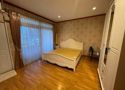 Spacious bedroom with wooden flooring and a large bed