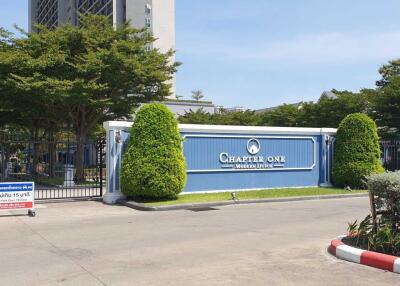 Entrance to Chapter One condominium complex with visible sign and surrounding greenery