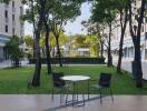 Outdoor communal area with greenery, tables, and chairs