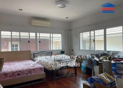 Spacious bedroom with multiple windows and two beds