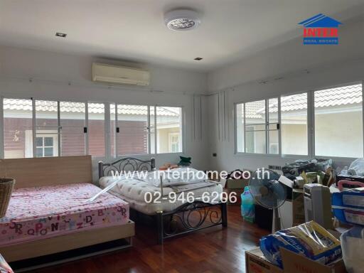 Spacious bedroom with multiple windows and two beds