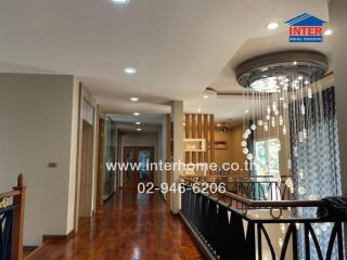 Interior hallway with chandeliers and wood flooring