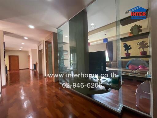 Spacious hallway with glass partition and wooden flooring