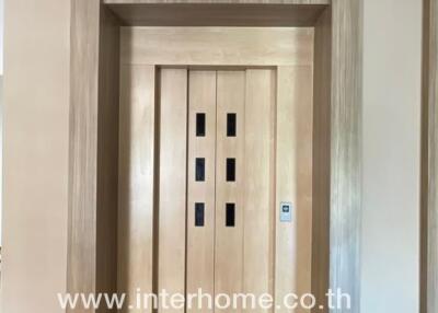 Elevator inside a residential building with wooden doors and floor