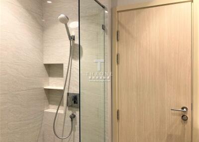 Modern bathroom shower area with wooden door