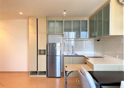 Modern kitchen with wooden cabinetry, stainless steel appliances and integrated dining area