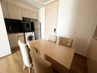 Modern kitchen and dining area with light wood cabinets and table