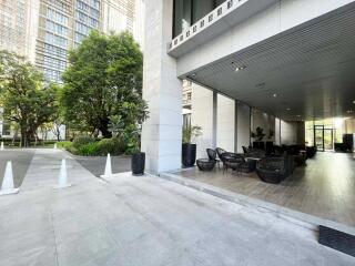 Outdoor and indoor lounge area of a building with surrounding greenery