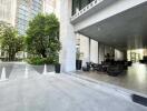 Outdoor and indoor lounge area of a building with surrounding greenery