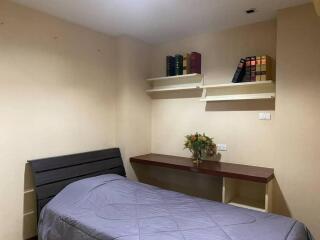 Cozy bedroom with single bed, desk and bookshelf