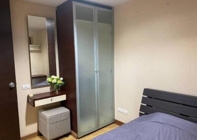 Bedroom with a wardrobe, mirror, bed, and a small storage bench