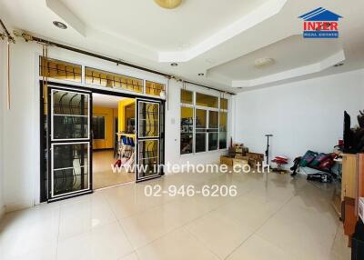 Spacious living room with large windows and modern tiles