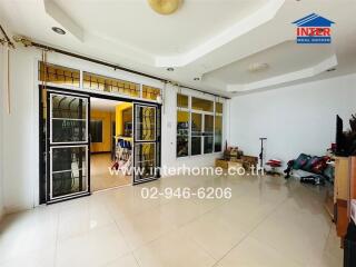 Spacious living room with large windows and modern tiles