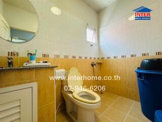 Bright bathroom with tiled walls and toilet