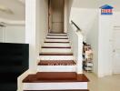 Modern staircase in residential building with white walls and dark wood steps