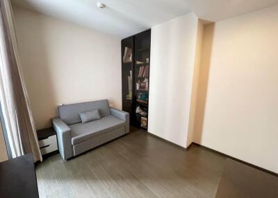 Minimalistic living room with a gray sofa and bookshelf