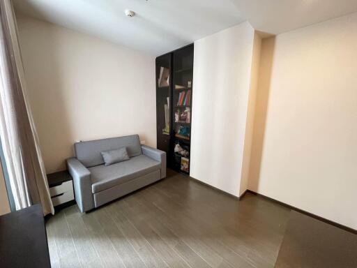 Minimalistic living room with a gray sofa and bookshelf