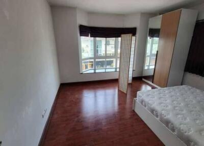 Spacious bedroom with wooden flooring, large windows, and a double bed