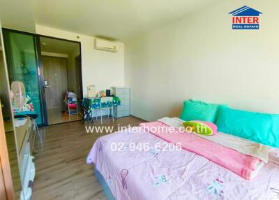 Bright and inviting bedroom with colorful bedding, air conditioning, and ample storage space