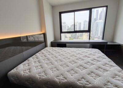 Modern bedroom with a large bed and city view