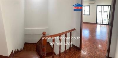 Interior view showing staircase, room with wooden floors, and windows