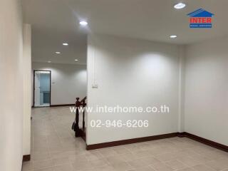 Interior photo showing a hallway and a staircase with tile flooring