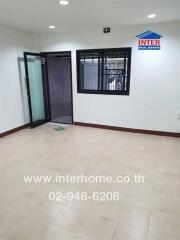 Bright empty room with tiled floors, large window, and glass door