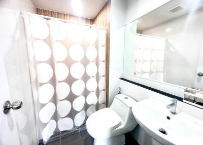 Modern bathroom with shower curtain, toilet, and sink