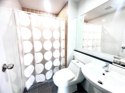 Modern bathroom with shower curtain, toilet, and sink