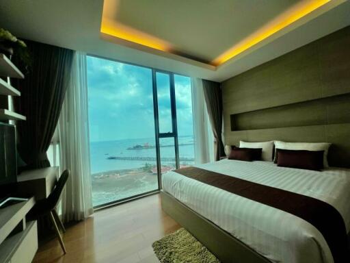 Modern bedroom with large window and scenic ocean view