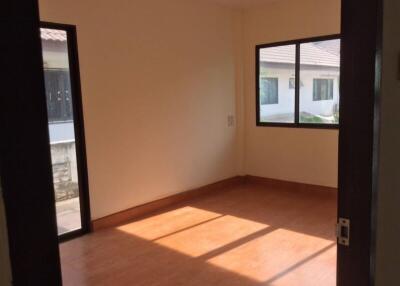 Empty bedroom with wooden floor and large windows