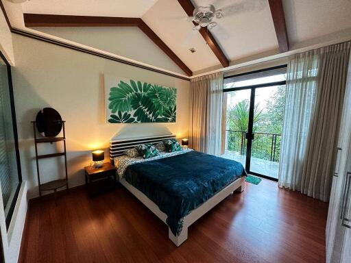 Cozy bedroom with large windows, wooden floors, and modern decor