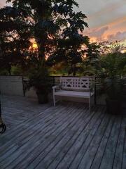 Outdoor patio with bench and potted plants at sunset