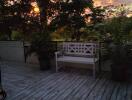 Outdoor patio with bench and potted plants at sunset