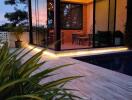 Modern glass-enclosed patio with a view of the pool and lush greenery