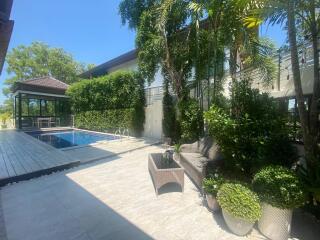 Outdoor patio with swimming pool and lush greenery