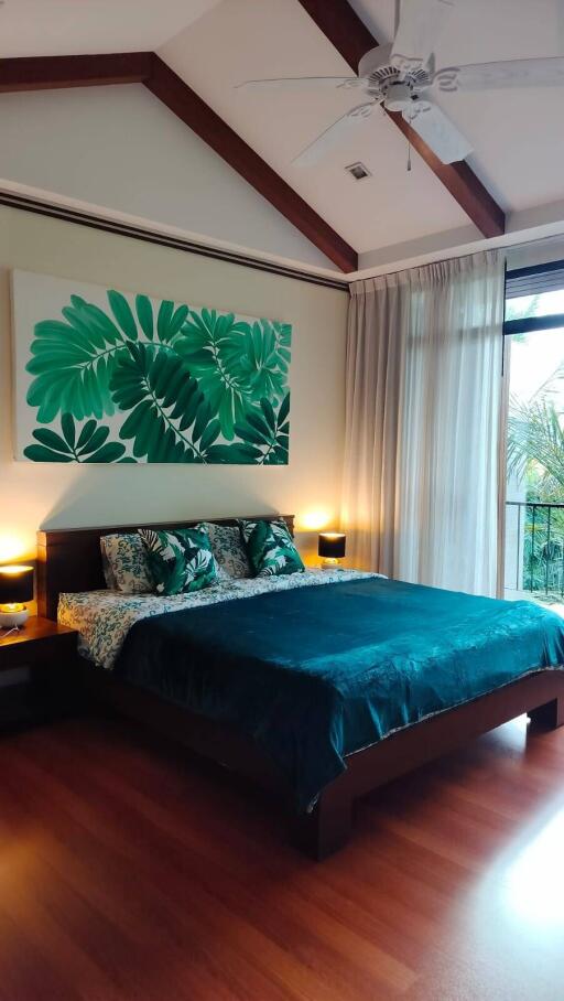 Modern bedroom with large window and tropical-themed decor