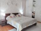 Cozy and well-lit bedroom with double bed, decorative pillows, and large wardrobe