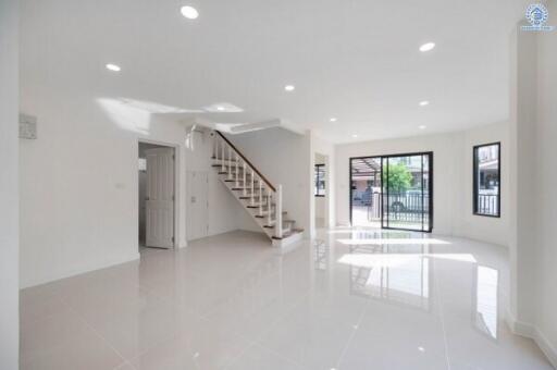 Spacious living area with staircase and large windows